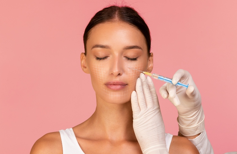 Beautician Doctor making injection to woman with drawn mesh on face