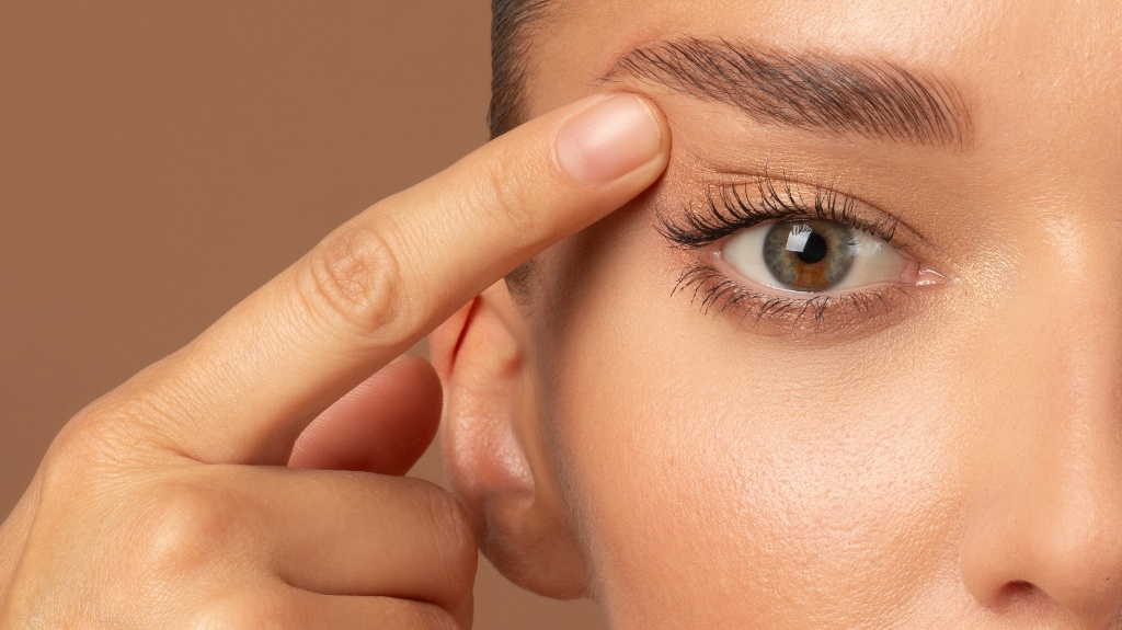 woman pointing to the upper eyelid